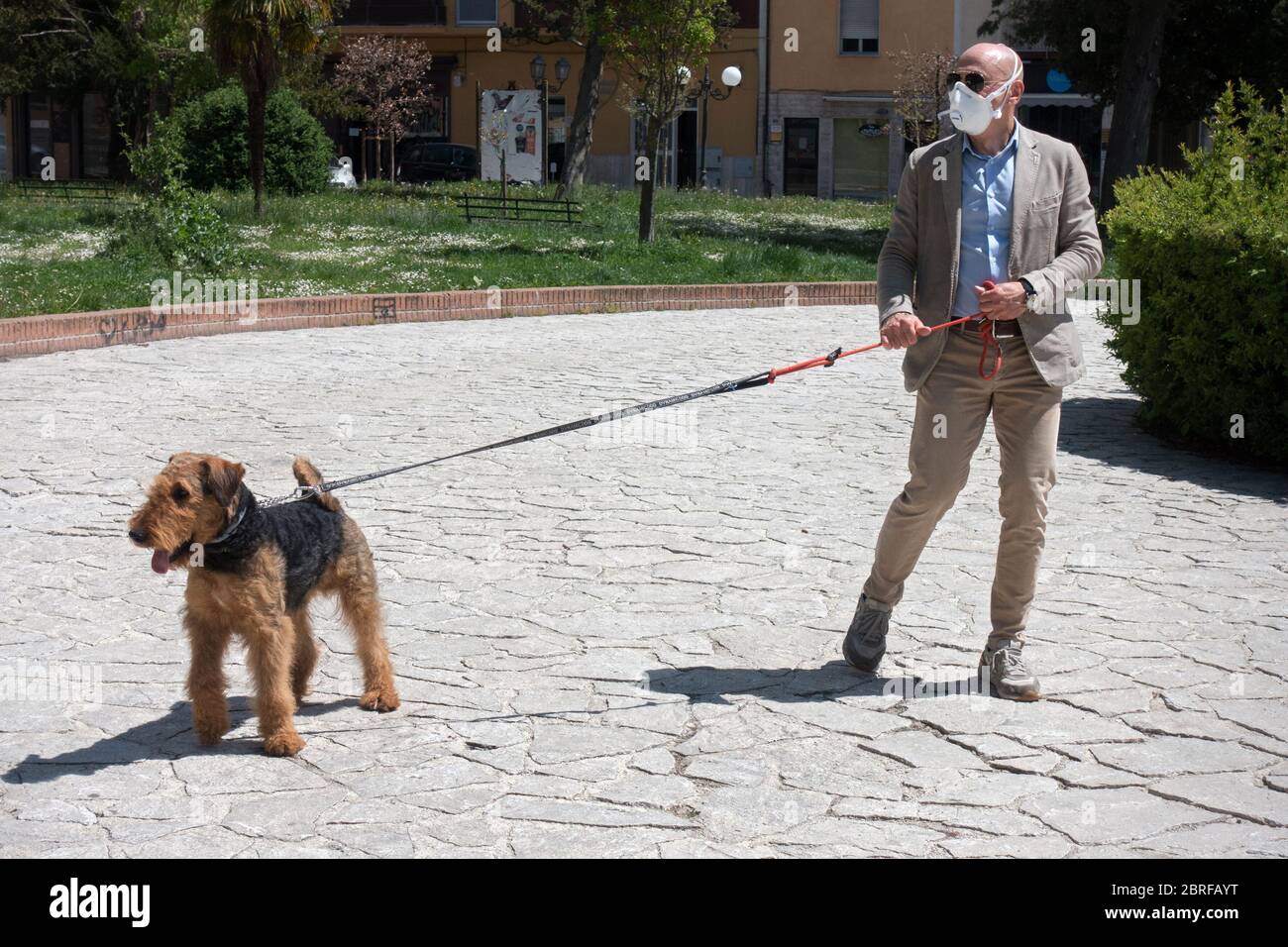 Campobasso,Molise regione,Italia:UN uomo con il suo cane passeggerà in un parco cittadino durante l'emergenza del coronavirus in Italia. Foto Stock