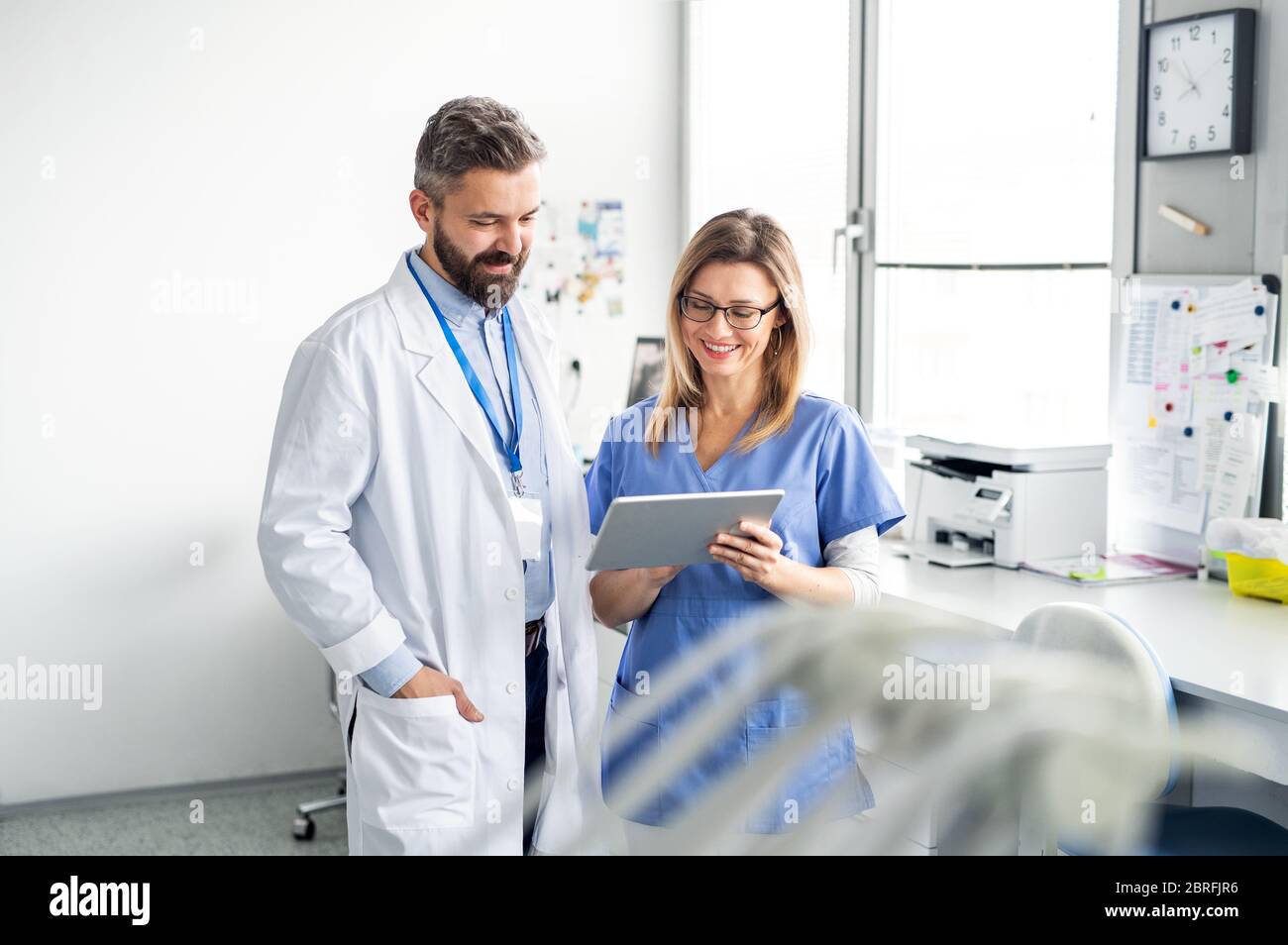 Dentista con assistente dentale in moderna chirurgia dentale, lavorando. Foto Stock