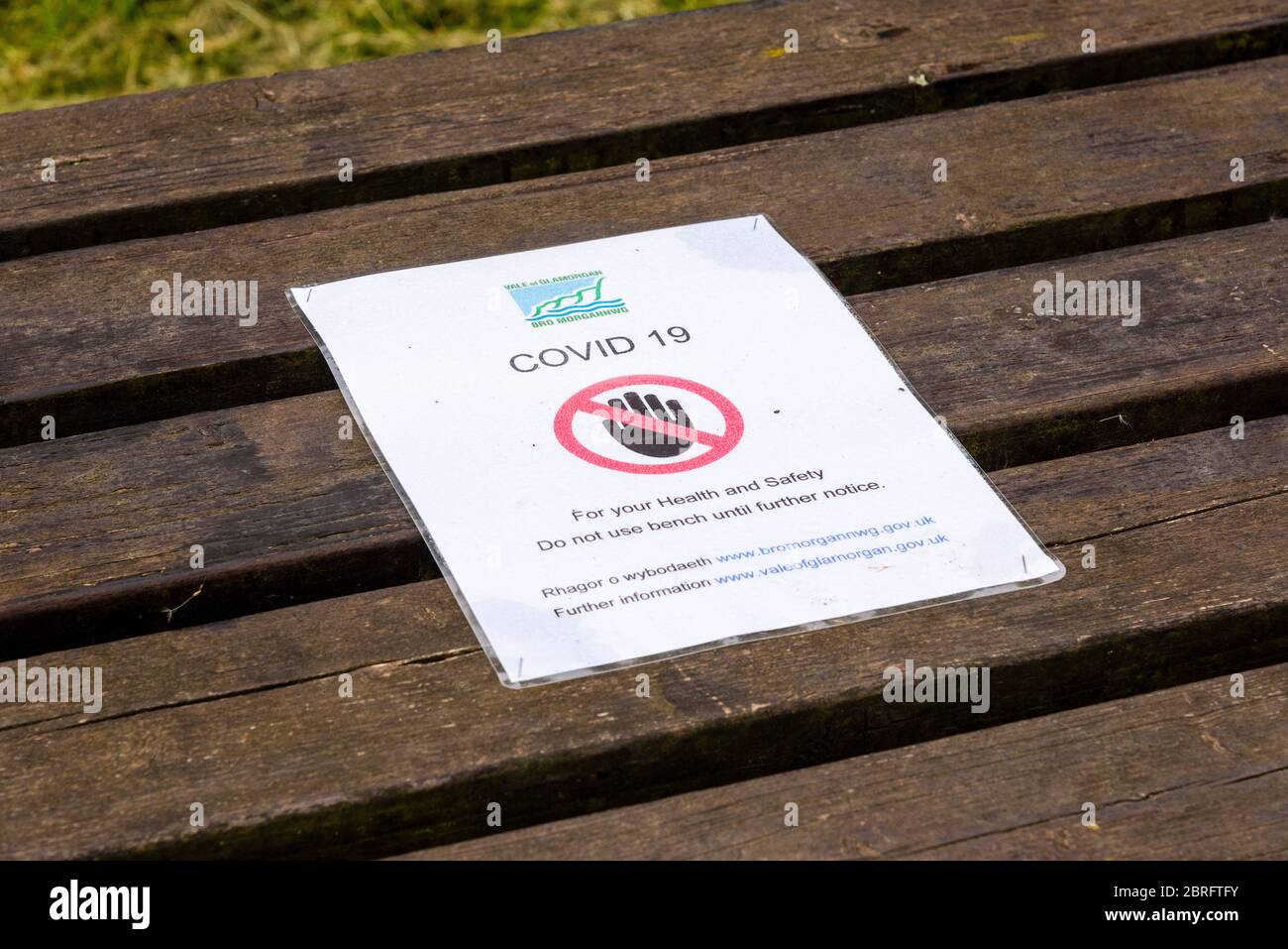 Primo piano di un avviso temporaneo del consiglio, pinzato su un tavolo da picnic che vieta l'uso del tavolo a causa delle norme di salute e sicurezza del Covid 19. Foto Stock