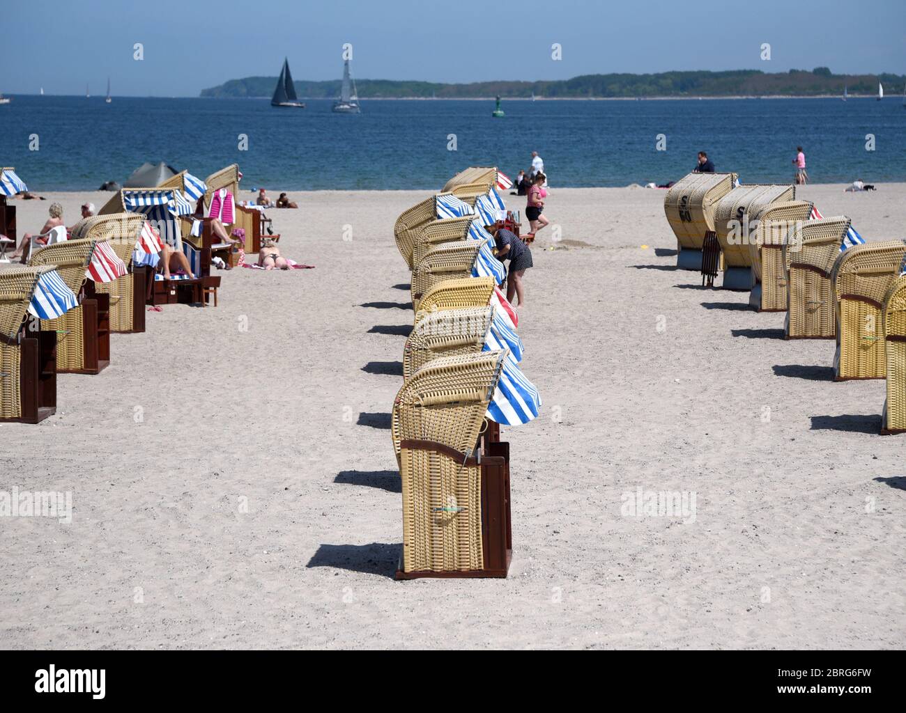 21 maggio 2020, Schleswig-Holstein, Lübeck-Travemünde: Solo poche sedie da spiaggia sono occupate sulla spiaggia del Mar Baltico. A causa delle regole di distanza durante la corona Pandemic, le sedie a sdraio sono anche situate a pochi metri di distanza. Foto: Daniel Bockwoldt/dpa Foto Stock