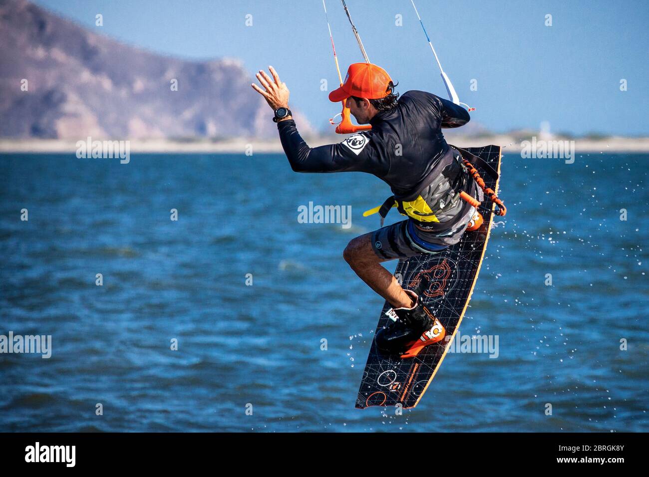 Un kitesurfer vola sopra l'acqua al largo dell'isola di Maviri a Topolampo, Sinaloa, Messico. Foto Stock