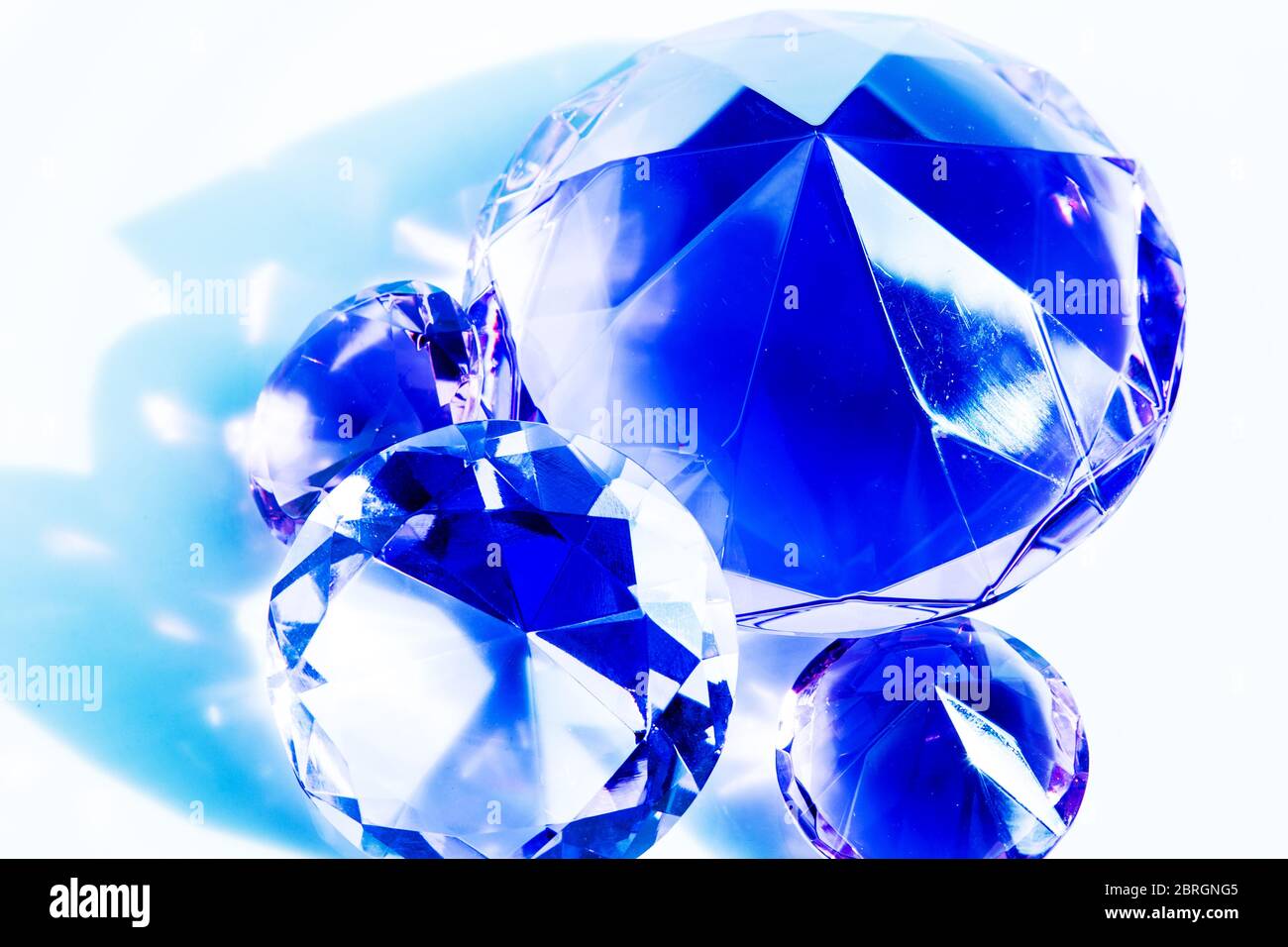 primo piano di diamanti blu brillanti su sfondo bianco Foto Stock
