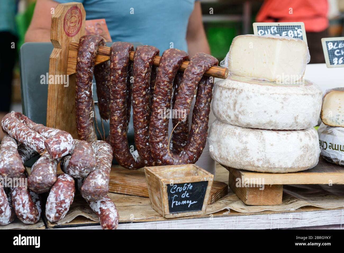 Saint-Palais-sur-Mer, Charente-Maritime / Francia: Varie salsicce francesi secche salate (saucisson) e ruote di formaggio disposti su un mercato. Foto Stock