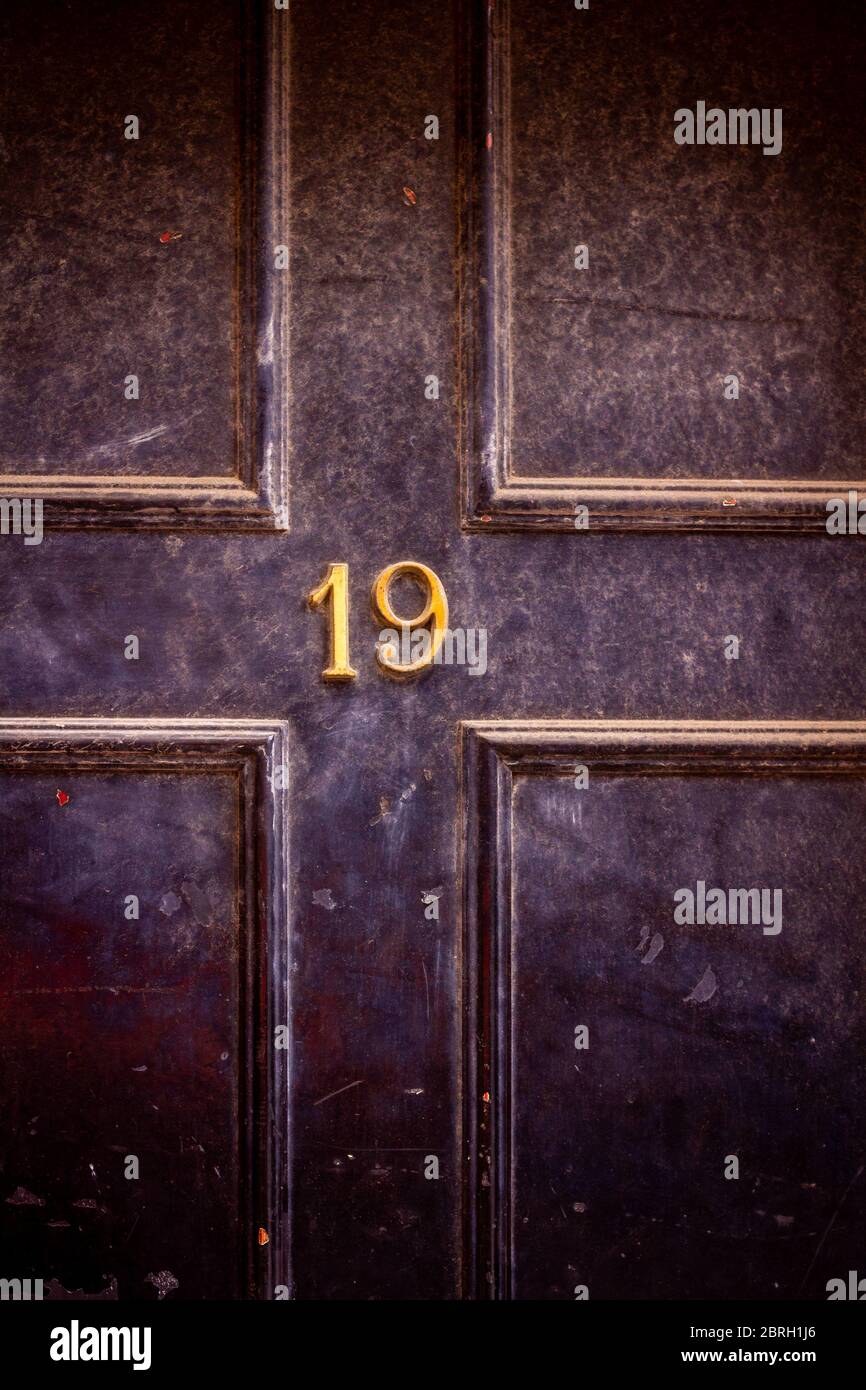Casa numero 19 su una porta di fronte di legno scuro a Londra Foto Stock