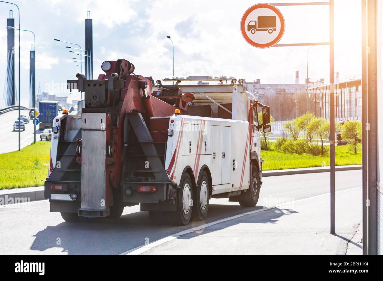 Il potente trattore semi-camion con carro di perforazione grande si sposta sull'autostrada urbana Foto Stock