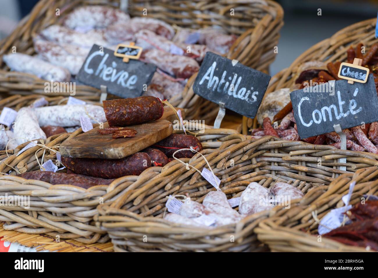 Saint-Palais-sur-Mer, Francia: Varie salsicce francesi secche salate (saucisson) su un mercato stalla - formaggio di capra, sapori di formaggio caraibico e Comté. Foto Stock