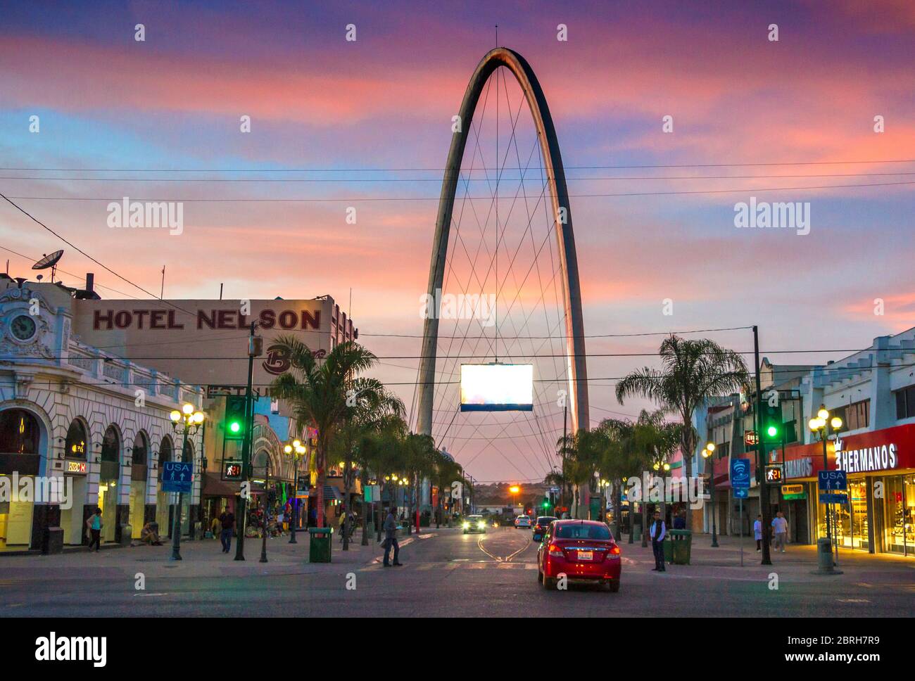 Avenida Revolucion (strada della Rivoluzione) con l'arco millenario (el arco y reloj monumentale) al crepuscolo. Tijuana, Messico Foto Stock
