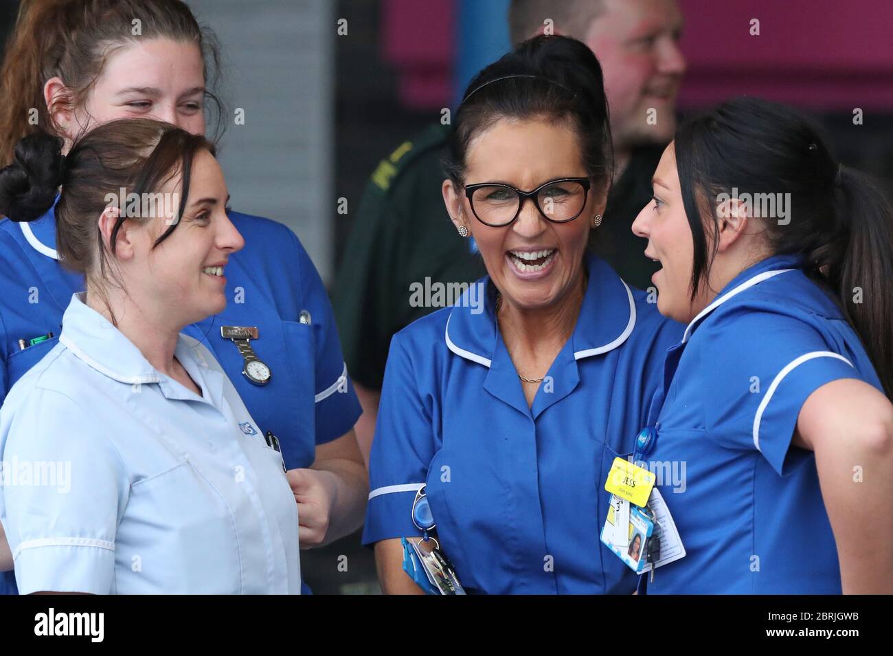 Il personale della NHS si riunisce fuori dall'Aintree University Hospital di Fazakerley, Liverpool, in vista degli applausi per salutare gli eroi locali durante l'iniziativa di giovedì del Nationwide Clap for Carers per riconoscere e sostenere i lavoratori e gli assistenti della NHS che combattono la pandemia del coronavirus. Foto Stock