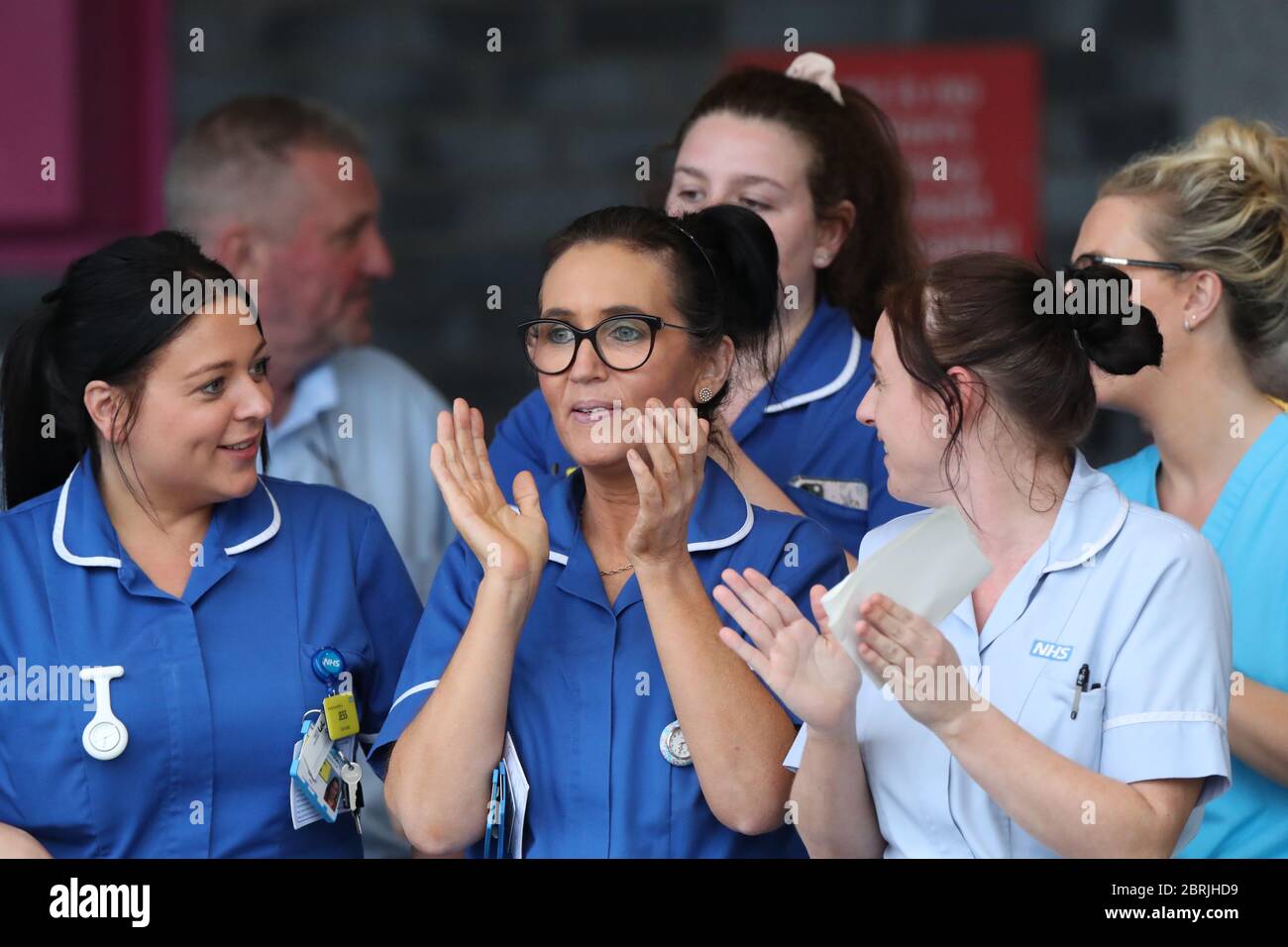 Personale NHS al di fuori dell'Aintree University Hospital di Fazakerley, Liverpool, durante l'iniziativa di giovedì Clap for Carers per riconoscere e sostenere i lavoratori e gli assistenti della NHS che combattono la pandemia del coronavirus. Foto Stock