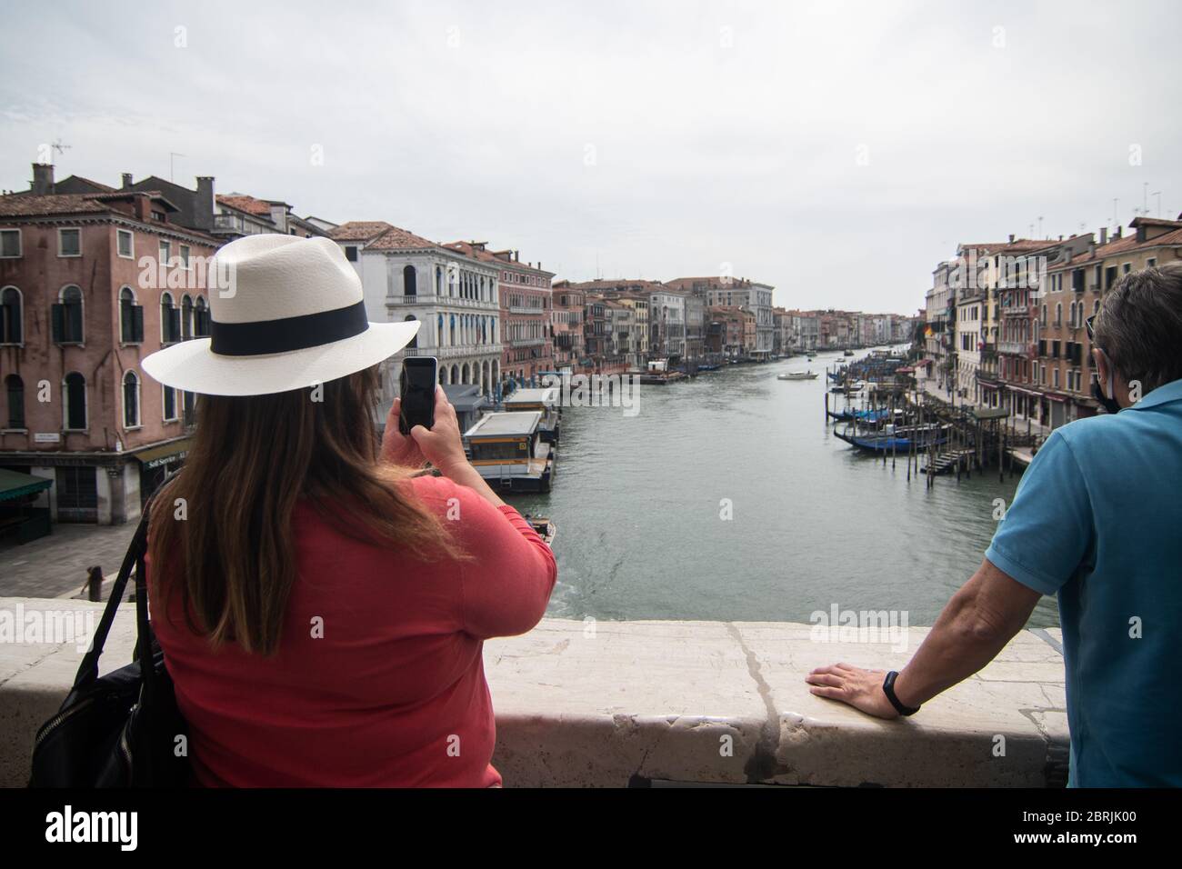 VENEZIA, ITALIA - MAGGIO: I turisti scattano foto dal Ponte di Rialto il 18 maggio 2020 a Venezia. Ristoranti, bar, caffè, parrucchiere e altri negozi Foto Stock