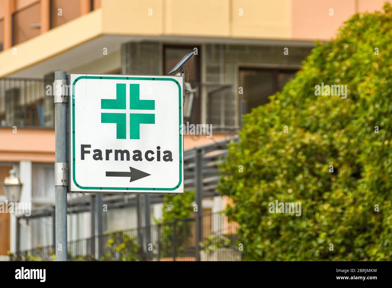 Lago DI COMO, ITALIA - GIUGNO 2019: Segno che mostra la strada per una farmacia in una delle città lungo il Lago di Como Foto Stock