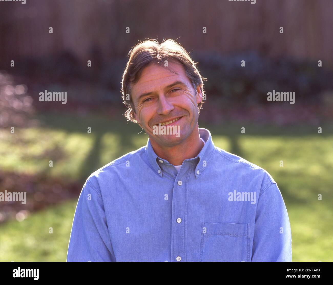 Uomo sorridente in giardino, Ascot, Berkshire, Inghilterra, Regno Unito Foto Stock