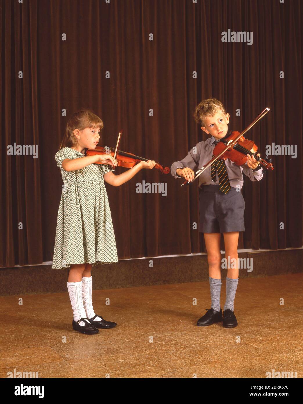 Giovane studentessa e ragazzo che suona violini in orchestra di scuola, Surrey, Berkshire, Inghilterra, Regno Unito Foto Stock