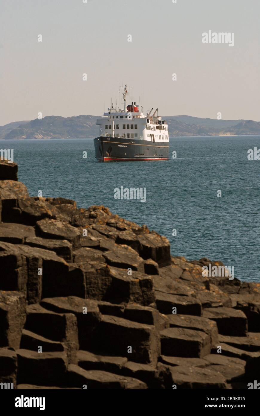 LA PRINCIPESSA EBRIDEA si trova all'ancora in una gloriosa giornata primaverile al largo DELLE COLONNE DI BASALTO che circondano LA GROTTA DI FINGALS, STAFFA, SCOZIA Foto Stock