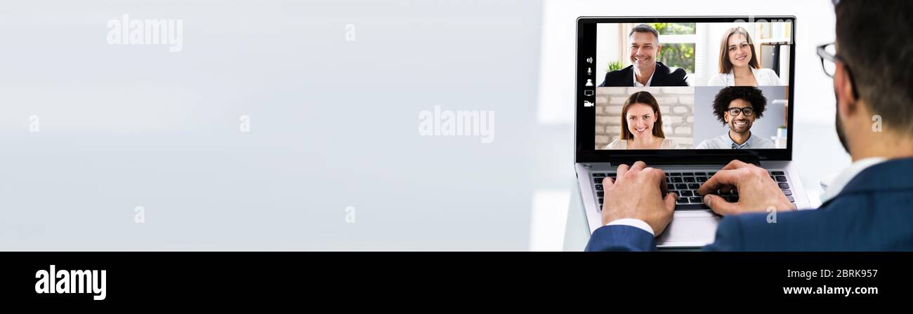 Uomo che lavora da casa avere un gruppo online videoconferenza su laptop Foto Stock