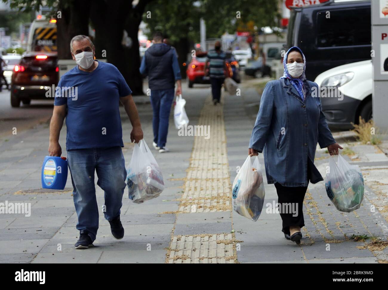 Ankara, Turchia. 21 Maggio 2020. Le persone che indossano maschere facciali camminano su una strada dopo lo shopping ad Ankara, Turchia, il 21 maggio 2020. Giovedì il Ministro della Sanità turco Fahrettin Koca ha confermato 961 nuovi casi giornalieri COVID-19 e 27 ulteriori morti in Turchia. Il numero totale di casi confermati nel paese è salito a 153,548. Credit: Mustafa Kaya/Xinhua/Alamy Live News Foto Stock