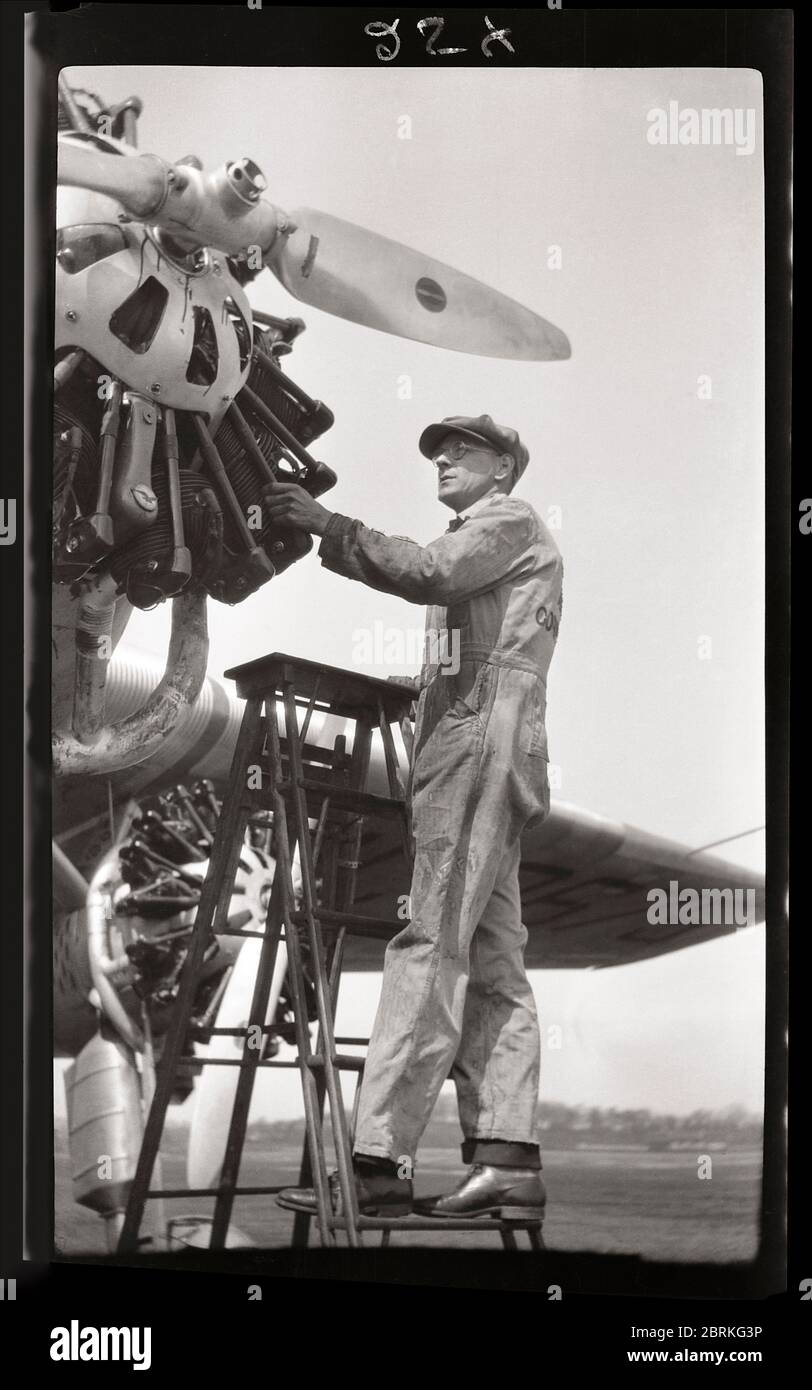 Il lavoratore addetto alla manutenzione ispeziona un aereo Ford Tri-Motor 1929. Questa vista mostra uno dei tre motori a pistoni radiali di questo storico velivolo da trasporto. Immagine da 2.5 x 4.25 pollici negativo. Foto Stock