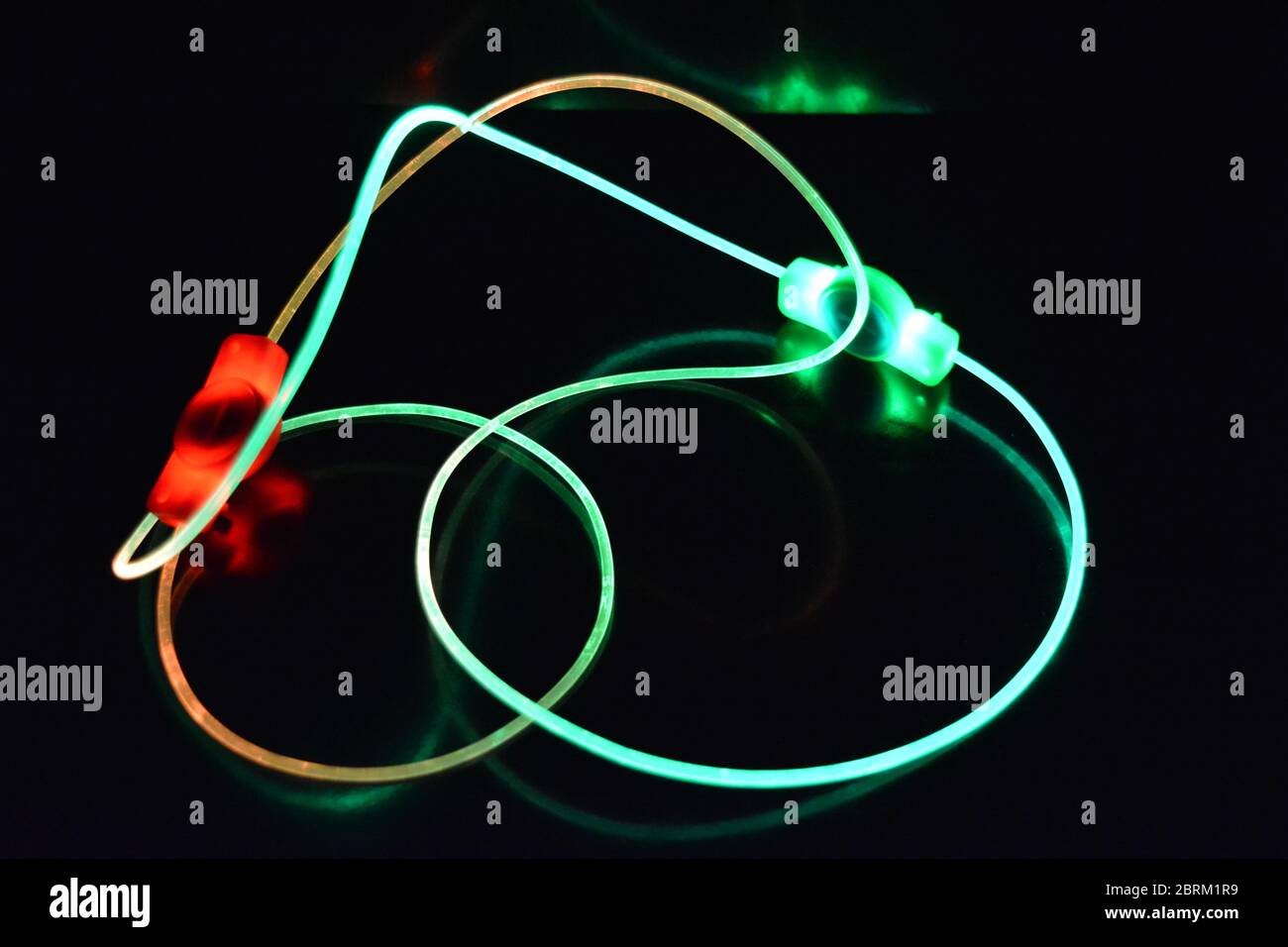 Filo con luce verde e rossa, un filo guida con trasmissione della luce diversa, spettro luminoso ed effetti luminosi situati in uno stato caotico. Foto Stock