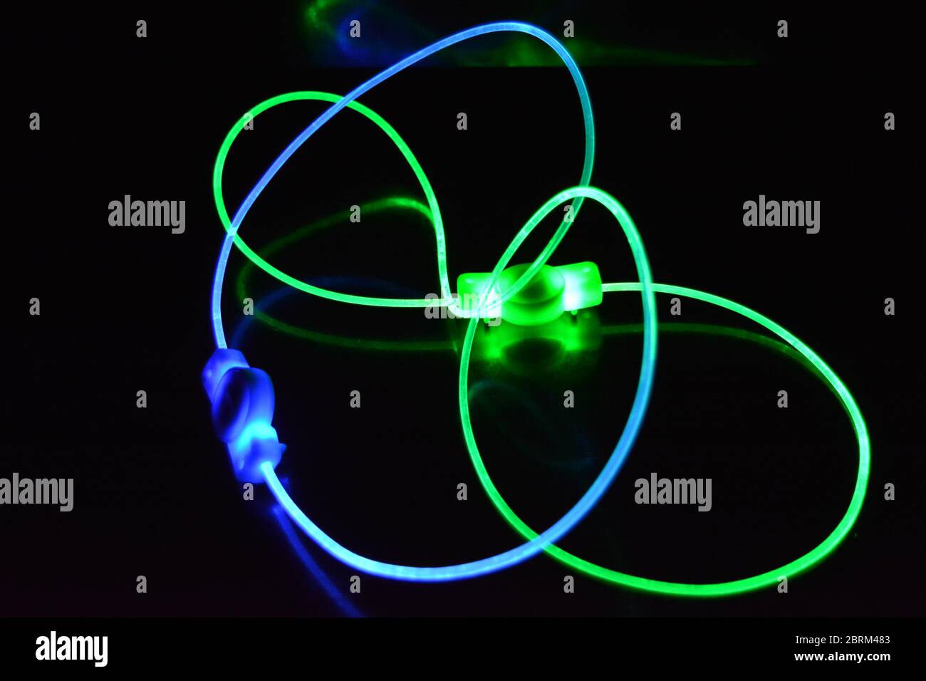 Filo luminoso verde e blu, un filo guida della luce con trasmissione della luce, spettro luminoso ed effetti luminosi diversi, situato in uno stato caotico. Foto Stock