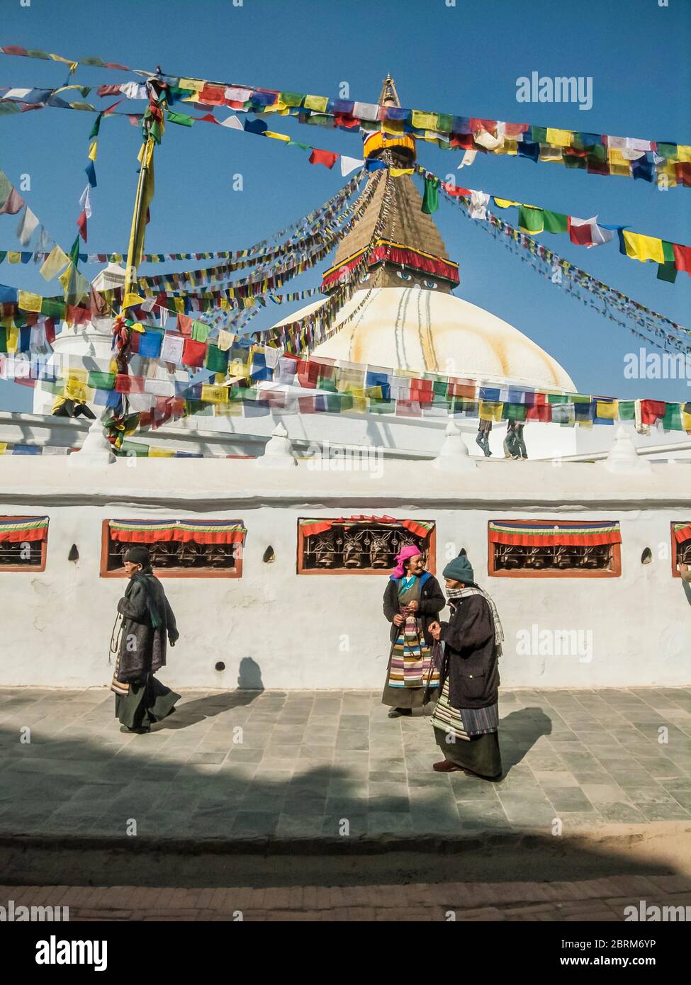 Kathmandu, Bodhnath. Scene colorate di strada con i fedeli adoratori al famoso Budhnath Buddista Temple Stupa e guglia, si ritiene che siano stati costruiti intorno al 15 ° secolo, è il più antico tempio in nepal. Foto Stock