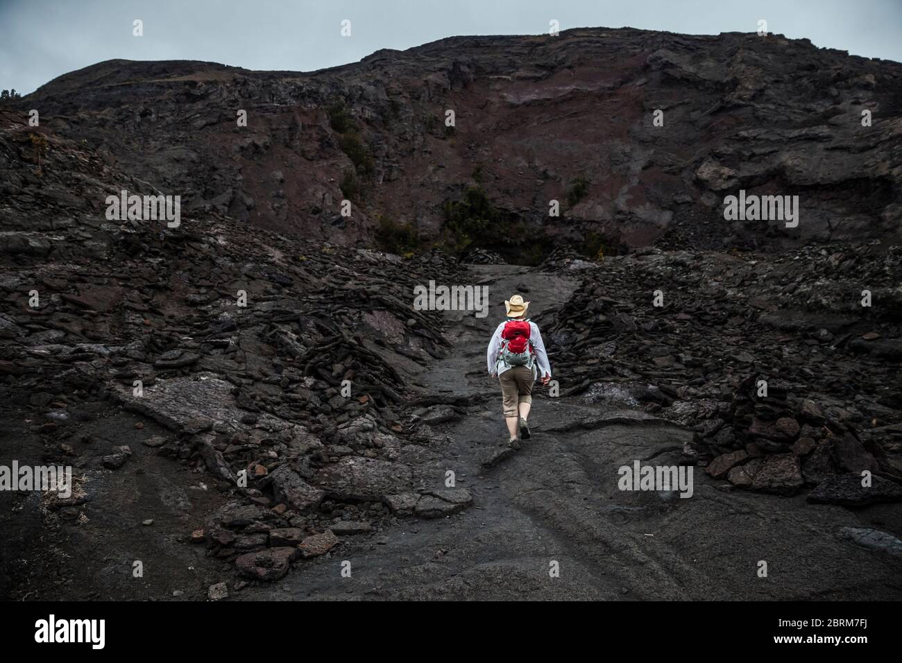 Una donna cammina verso pu’u Puaa'i o la Gushing Hill, una caratteristica vulcanica nel Parco Nazionale dei Vulcani delle Hawaii, Hawai'i, USA Foto Stock