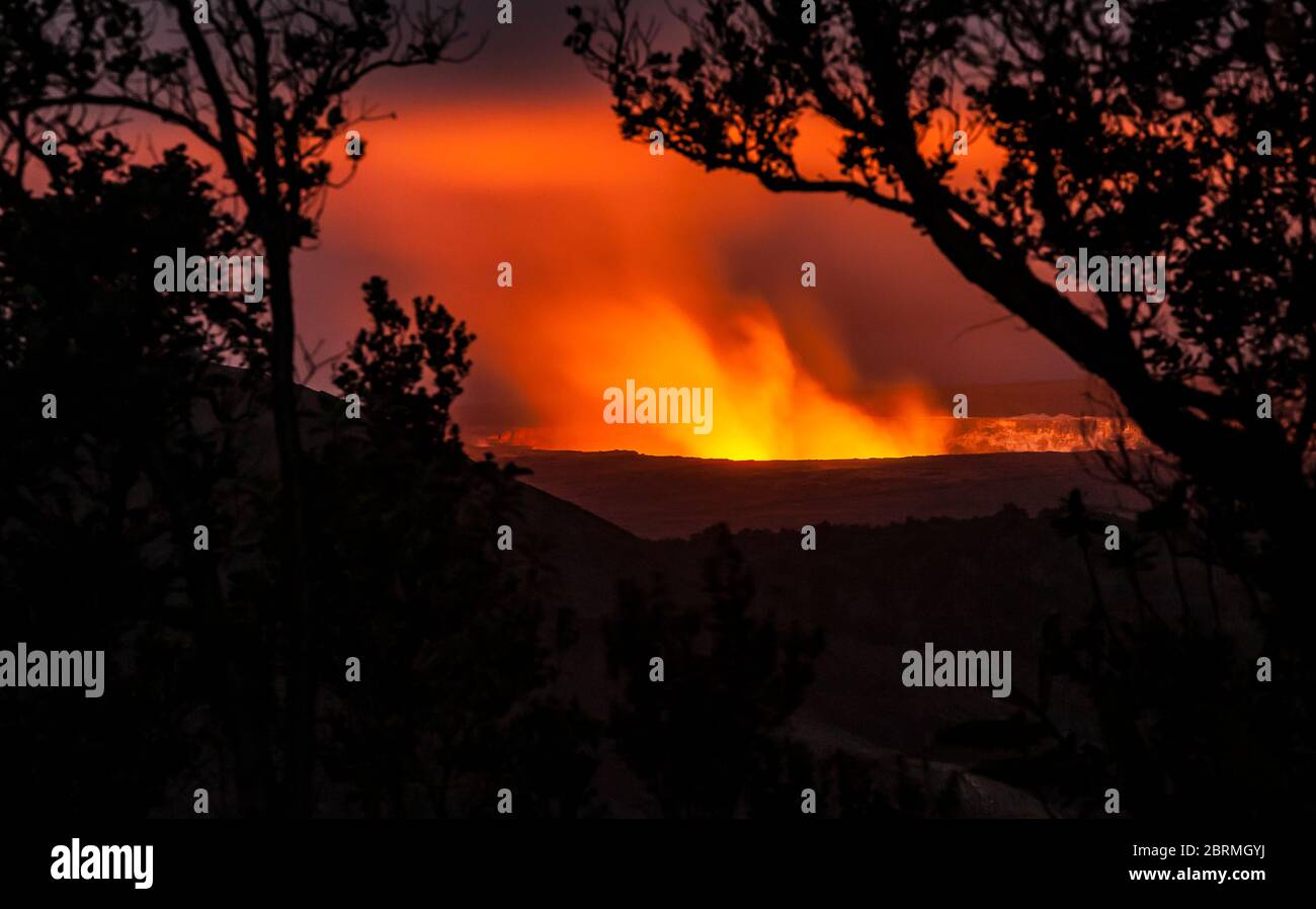 Kilauea Caldera è illuminata da gas che si sollevano e si inaridiscono e vapore dal lago di lava all'interno, visto dal centro visitatori, Hawaii Volcanoes Natia Foto Stock