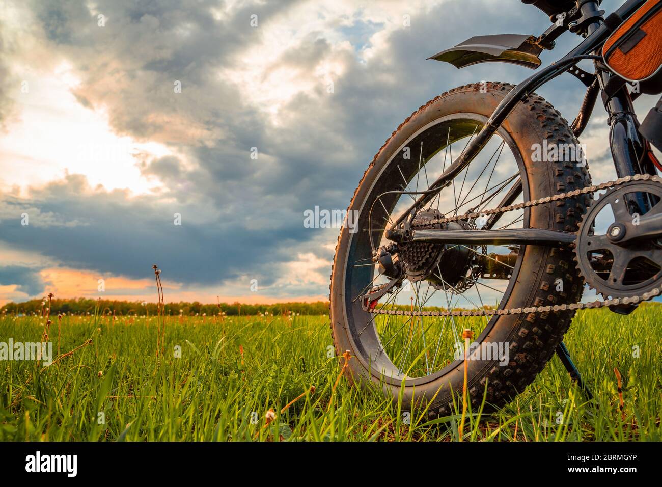 Una bicicletta con ruote spesse dotate di un motore elettrico. Fatbike contro un cielo bellissimo. Foto Stock