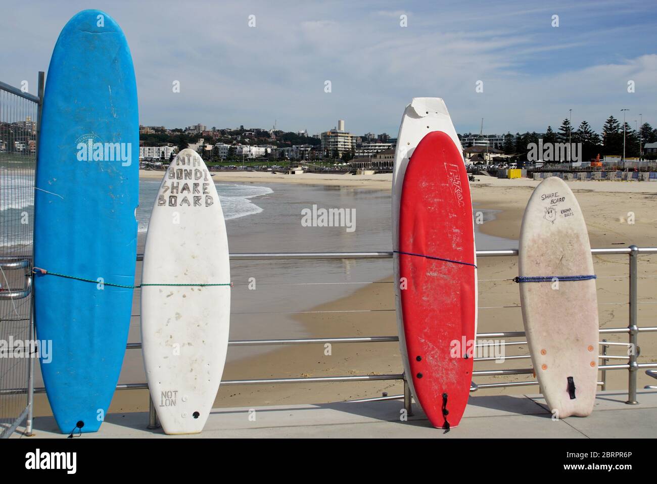 Fila di tavole da surf Lone Share appoggiate contro una railing a Bondi Beach durante le restrizioni Coronavirus Foto Stock
