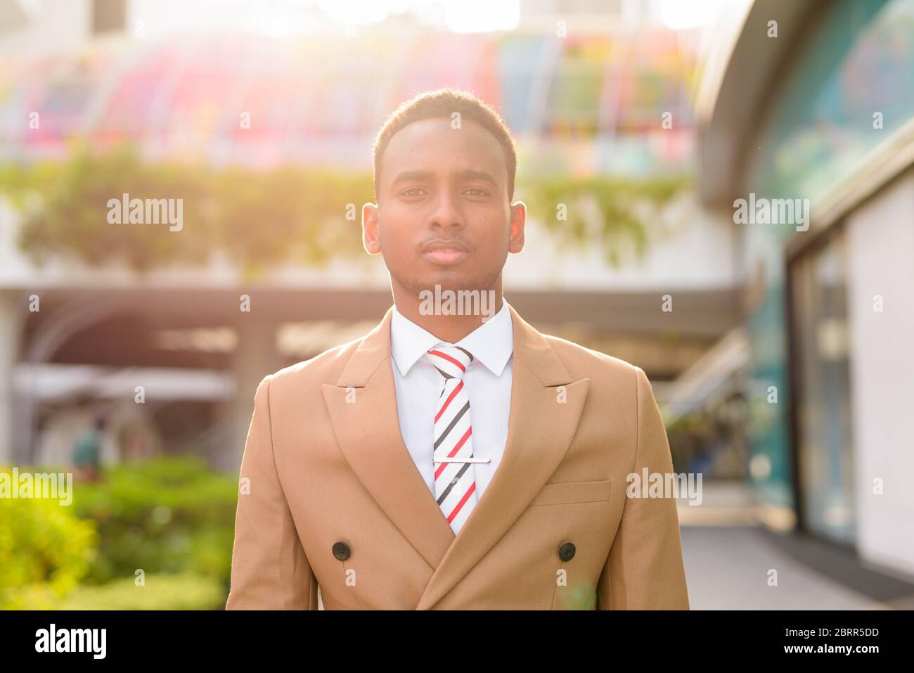 Giovane bell'uomo d'affari africano in città con la natura all'aperto Foto Stock