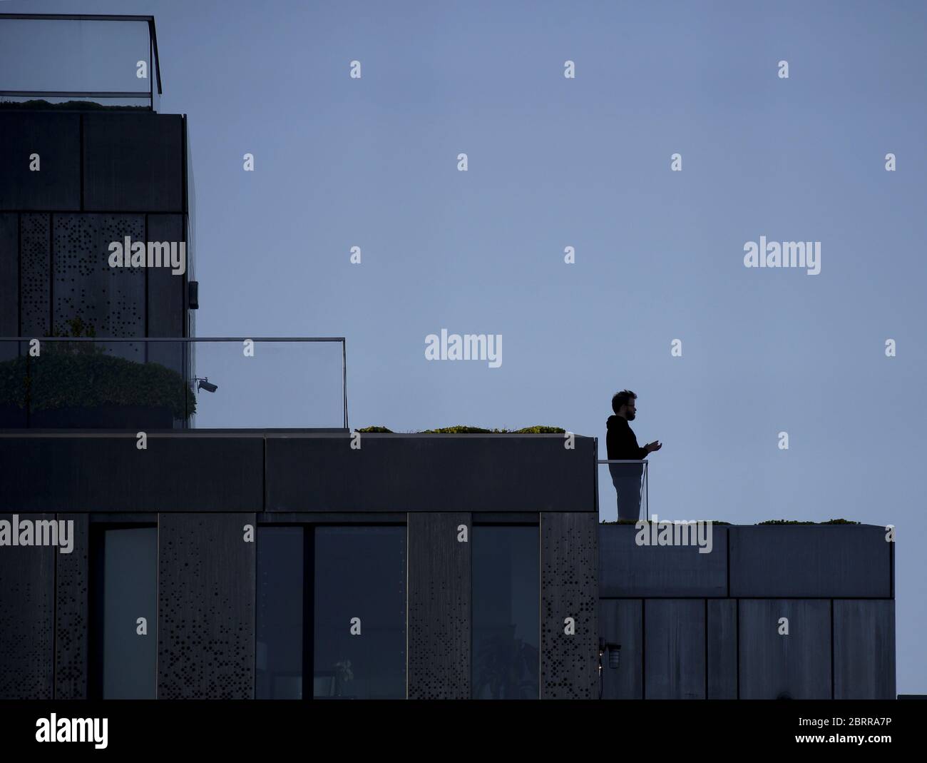 Williamsburg, Stati Uniti. 22 maggio 2020. Un uomo si erge su un balcone durante l'ora di ringraziamento e si augora di salutare e onorare i medici e gli operatori essenziali della città di New York giovedì 21 maggio 2020. Il numero di morti di Coronavirus degli Stati Uniti ora è superiore a 90,000 e il numero di casi segnalati supera i 1.5 milioni. Foto di John Angelillo/UPI Credit: UPI/Alamy Live News Foto Stock