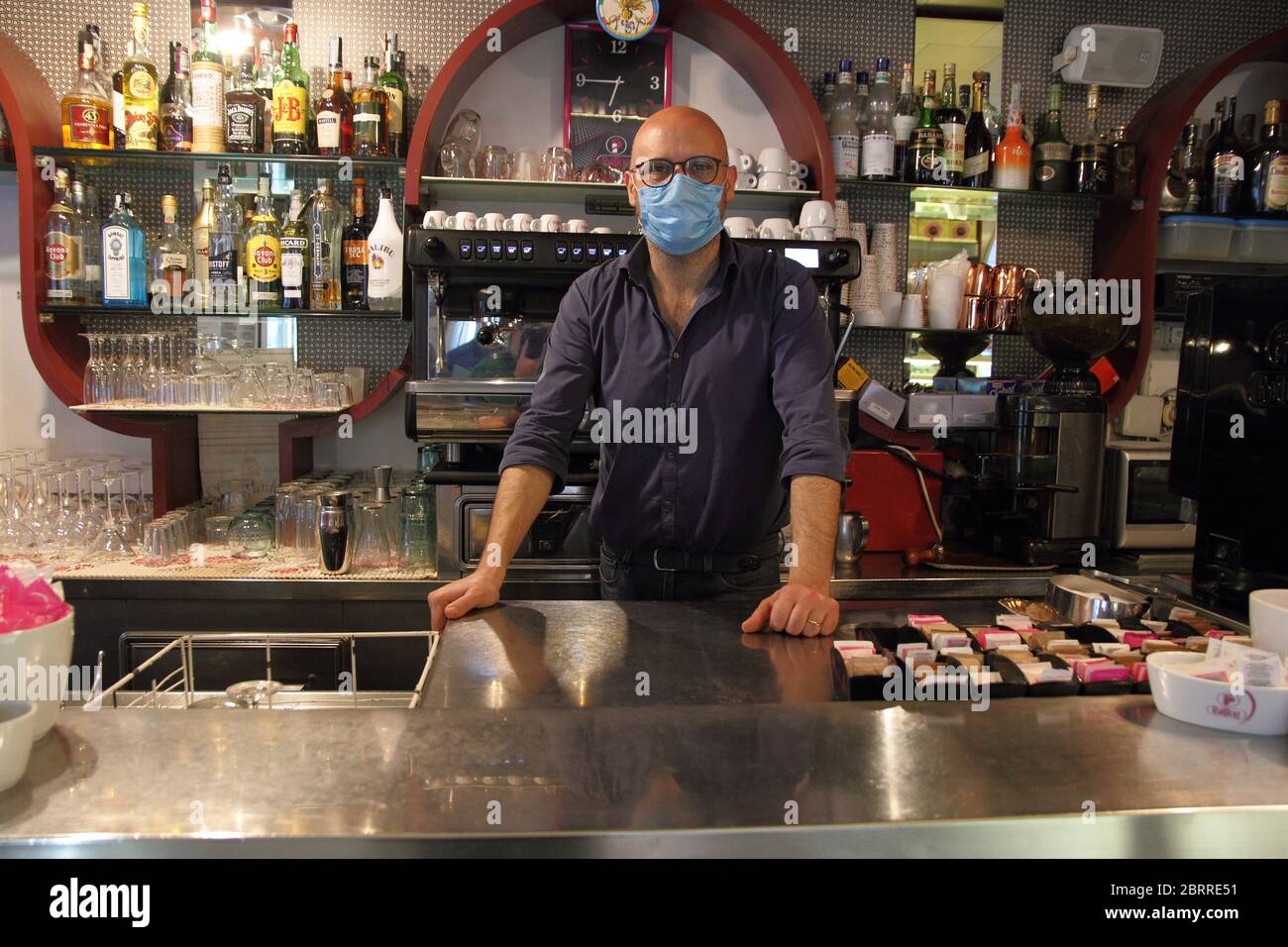 Il gestore di un bar e pasticceria nel centro della città alla riapertura della sua attività commerciale nella fase 2 dell'emergenza covid-19. Foto Stock