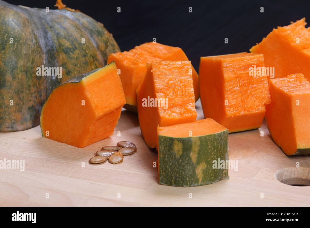 zucca gialla tagliata a pezzi su tavola di legno Foto Stock