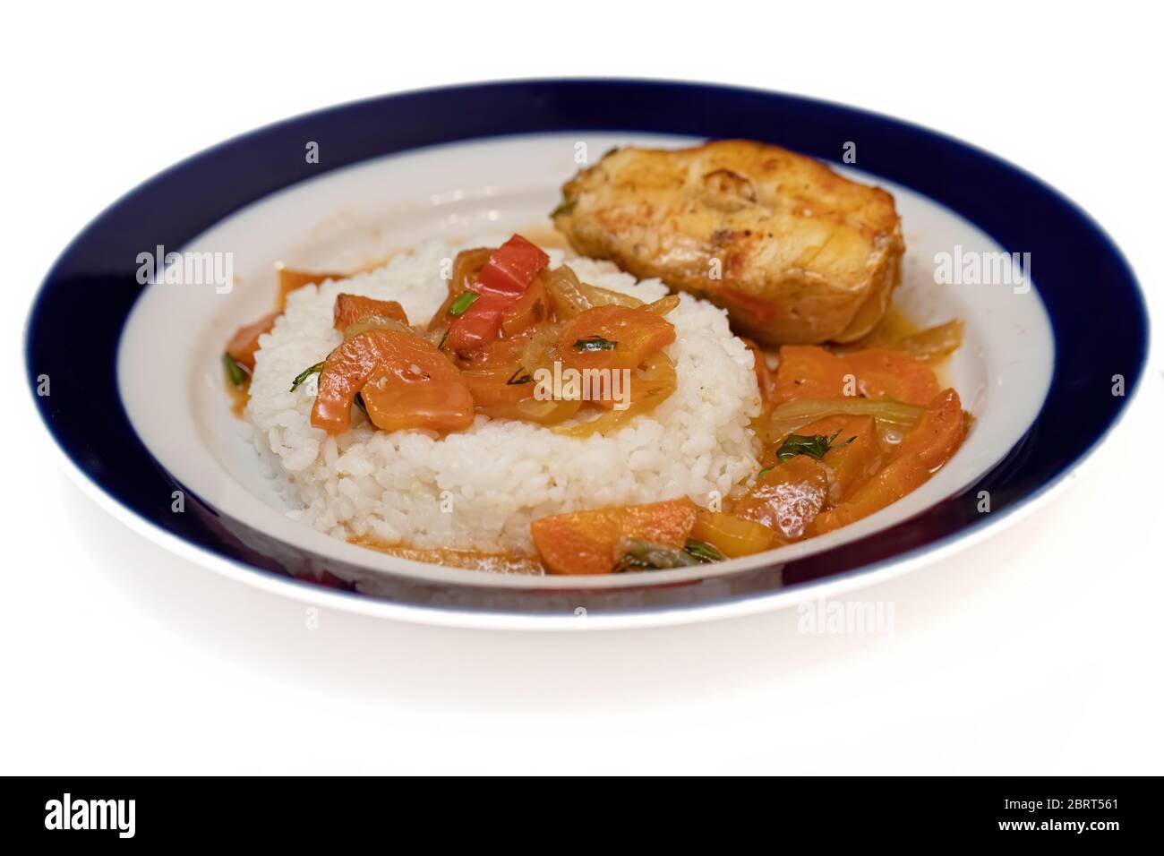 Il pesce viene cotto al forno con cipolle e fette di carote e servito con un contorno di riso. Concetto di dieta flessibile Foto Stock