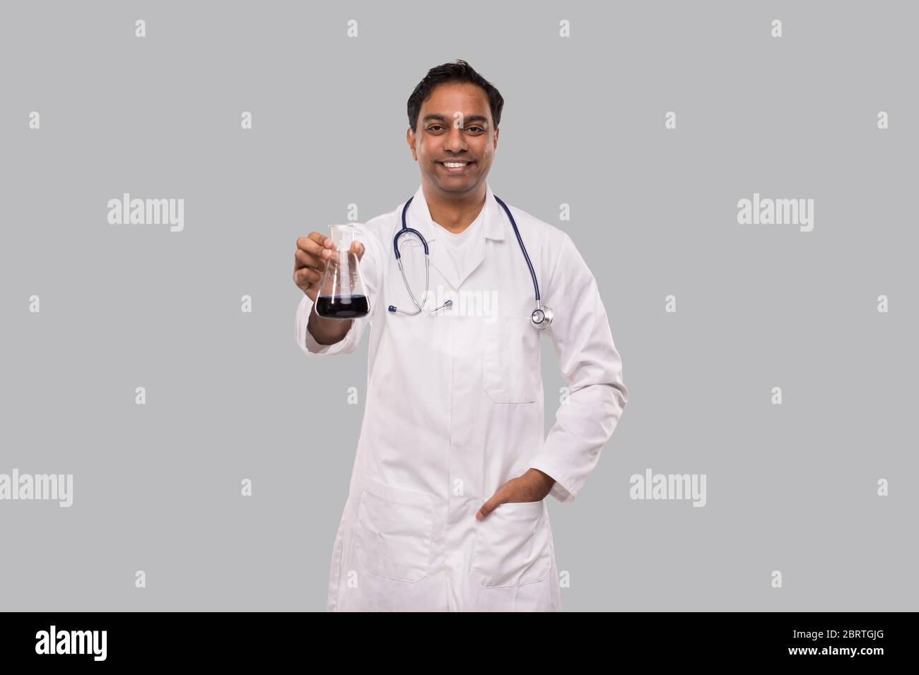 Beuta da medico maschile con liquido colorato isolato. Scienza, Medicina, Virus concetto. L'uomo indiano Dottore Smoling. Concetto Foto Stock