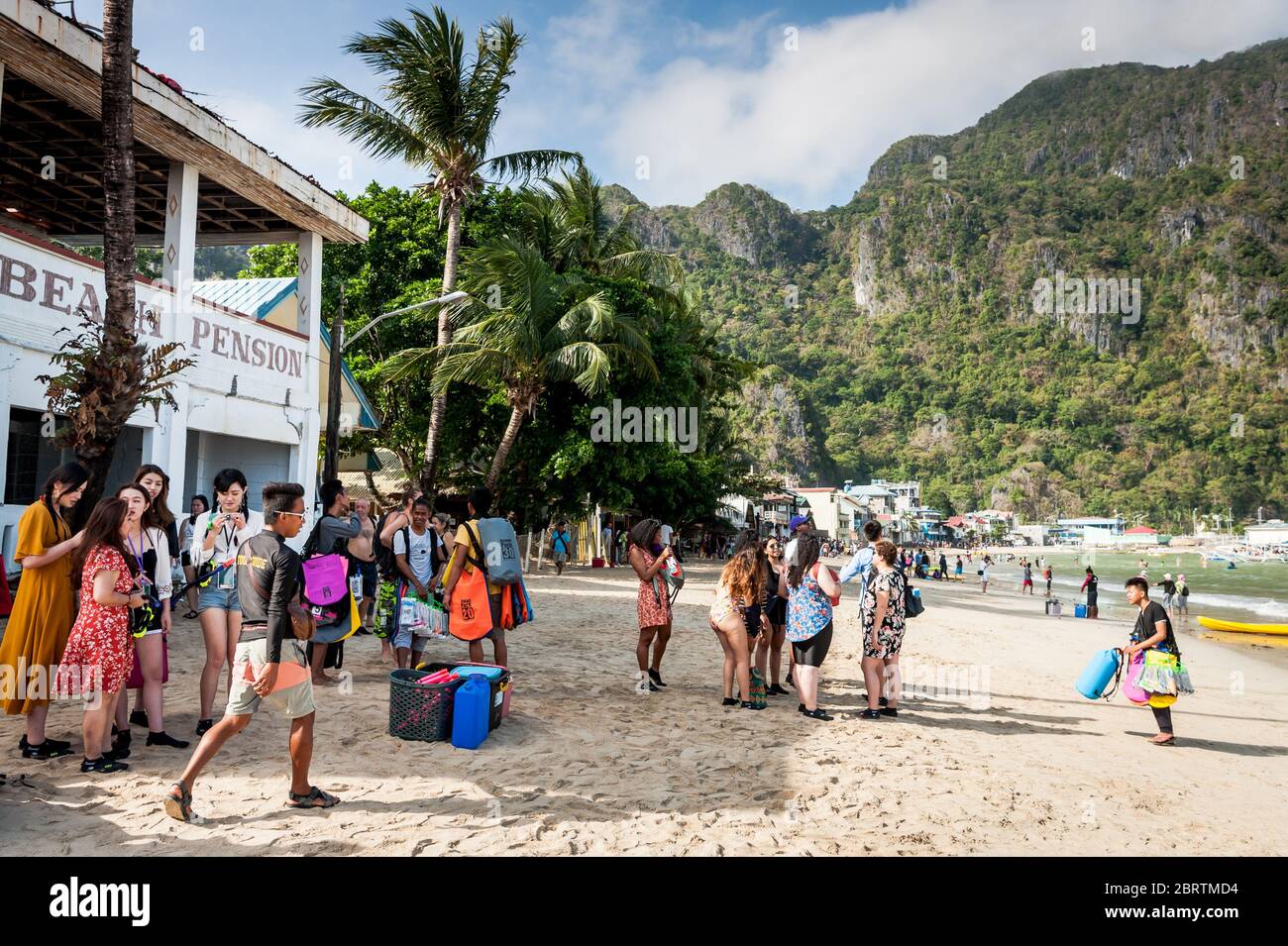 Scena mattutina sulla spiaggia principale di El Nido, Filippine, mentre i turisti iniziano a dirigersi sulle barche da giorno. Foto Stock