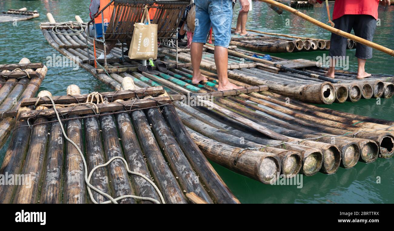 Yangshuo, Cina - Agosto 2019 : primo piano di gommoni di bambù per il trasporto di turisti guidato da guide sul panoramico e bel fiume Yulong Foto Stock