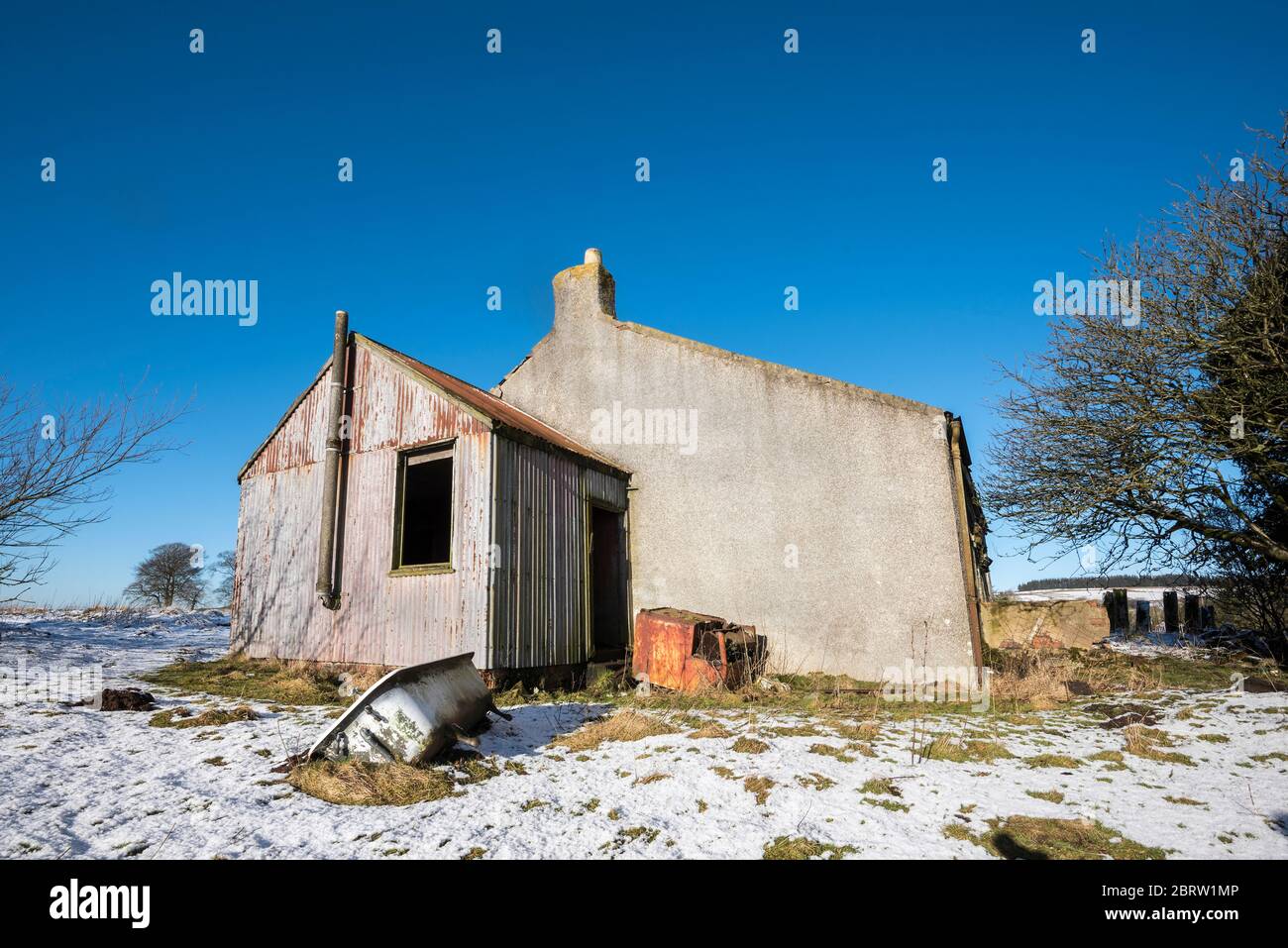 Casa derelict in neve coperta ambiente rurale nella campagna Lamarkshire Scozia. Foto Stock