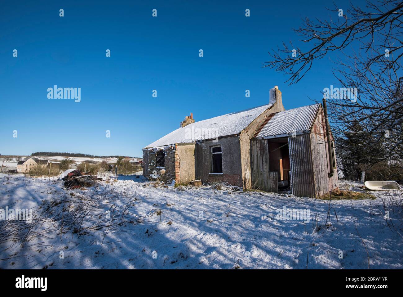 Casa derelict in neve coperta ambiente rurale nella campagna Lamarkshire Scozia. Foto Stock