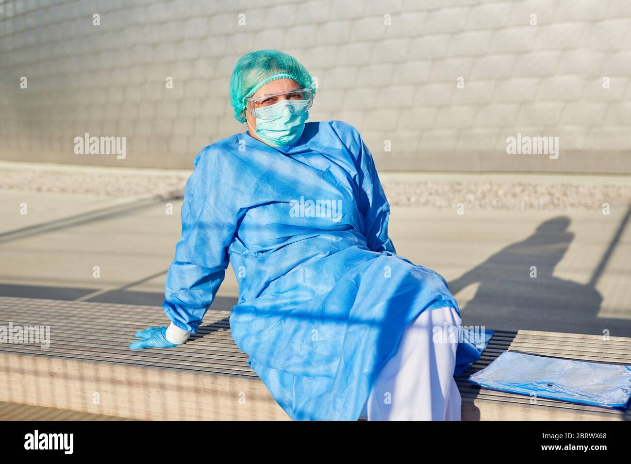 Dipendente come scout di contenimento davanti alla clinica con elenco per il monitoraggio dei contatti pause durante la pandemia di coronavirus Foto Stock