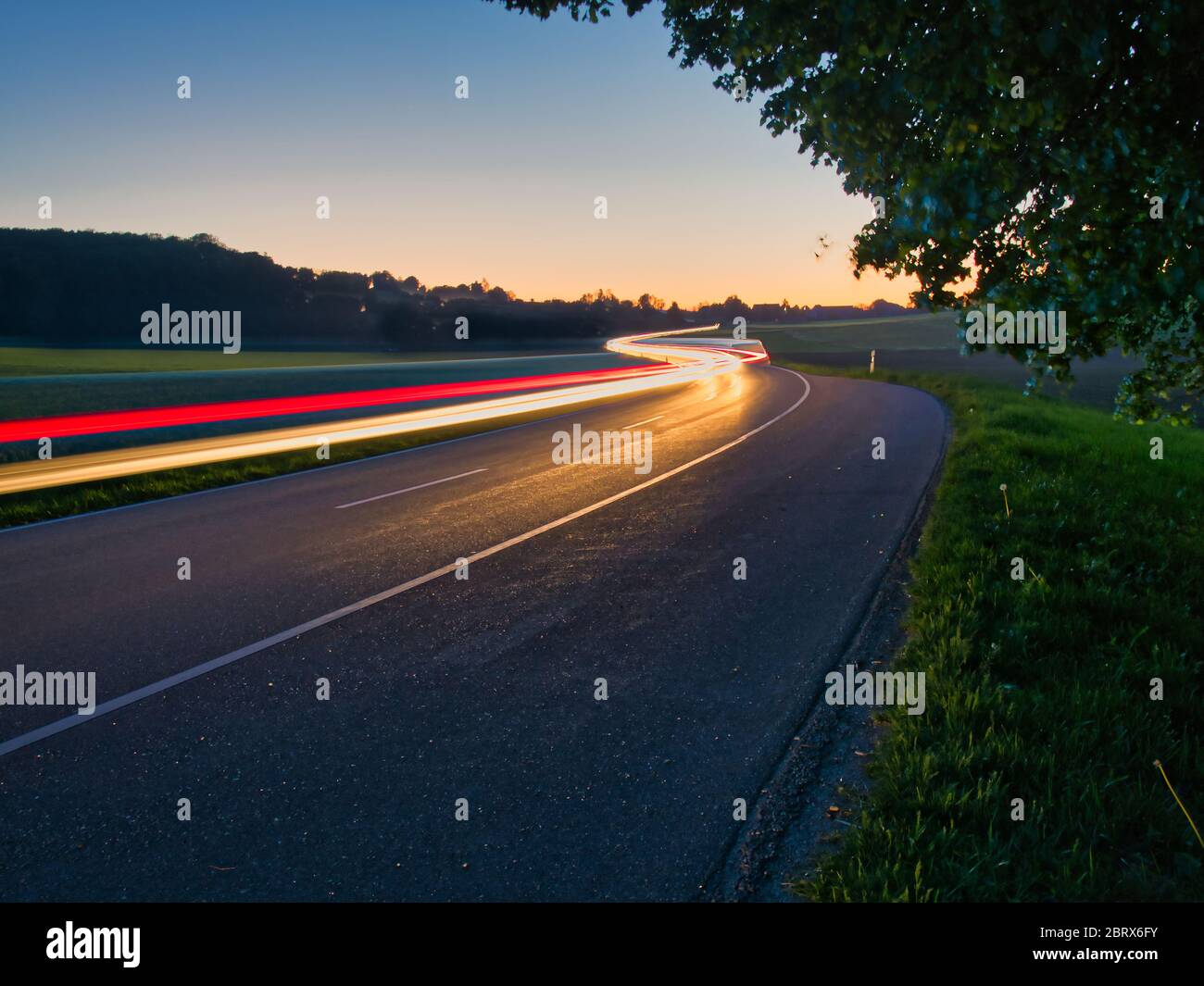 Traffico su strada non urbana con sentieri luminosi Foto Stock