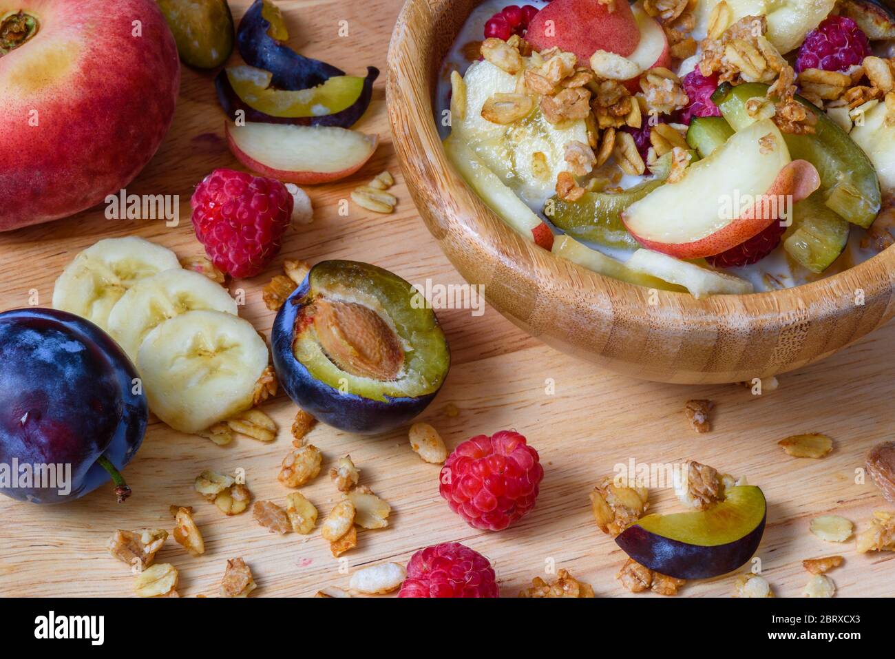 Muesli con frutti di bosco e frutta e latte - montare e sana prima colazione. Ingredienti sparsi e fette di frutta Foto Stock