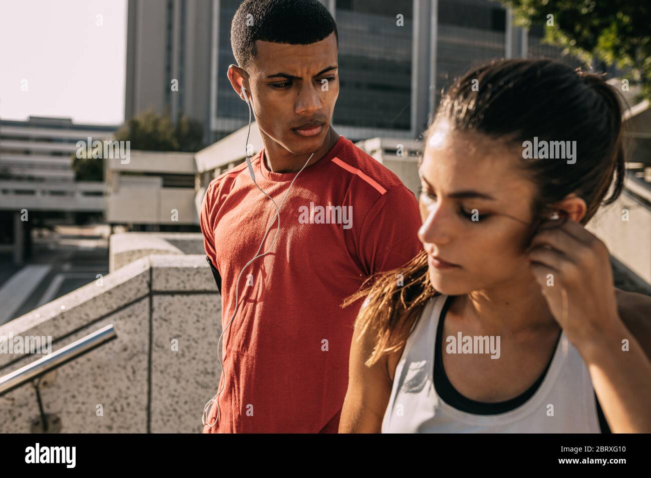 Una coppia in città per allenarsi al mattino. Uomo e donna in abbigliamento sportivo pronti per una corsa mattutina. Foto Stock