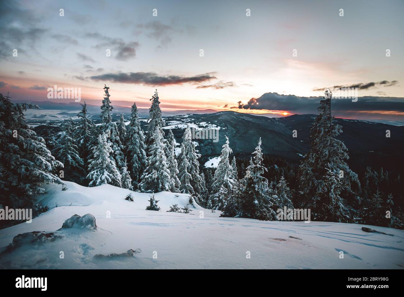 Maestoso tramonto in inverno le montagne paesaggio. Cielo drammatico Foto Stock