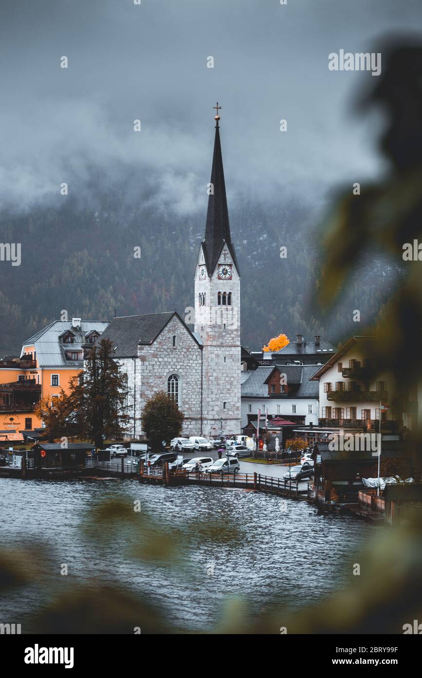 Splendida vista sulla moodia della chiesa di Christuskirche campanile con scale in primo piano. Moody scenario a Hallstatt, Austria Foto Stock