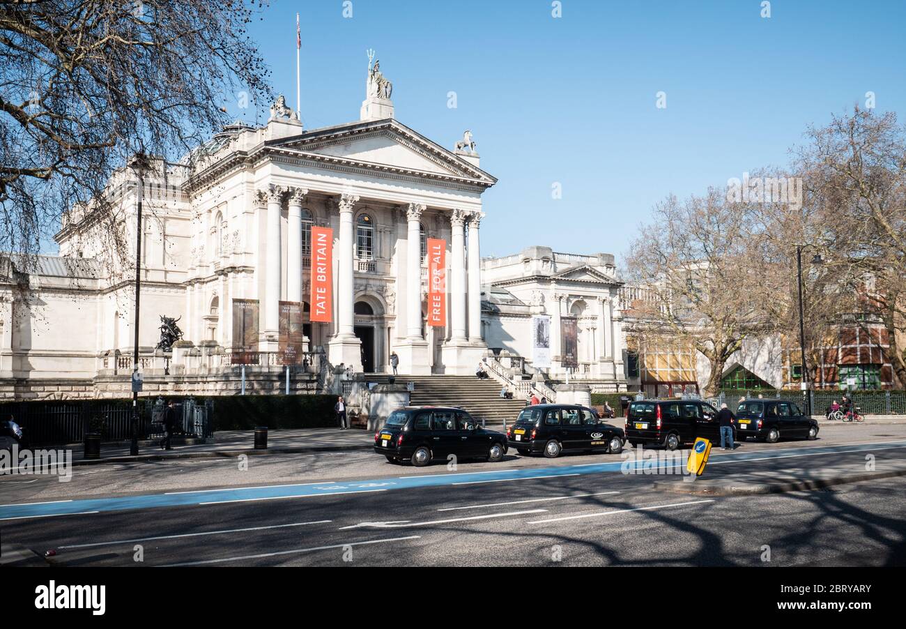 Il museo e la galleria Tate Britain a Millbank, Westminster, con un rango di taxi neri parcheggiati in attesa di un prezzo. Foto Stock