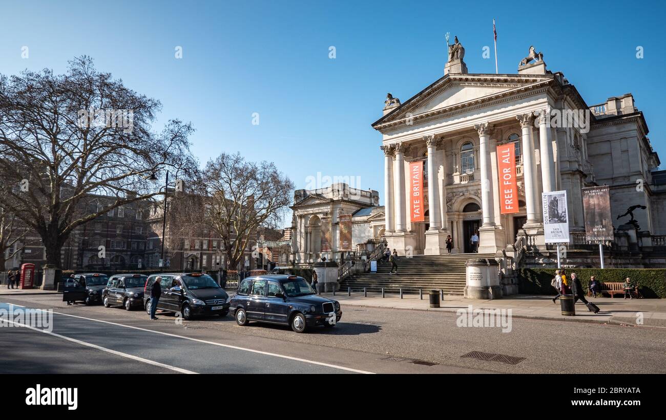 Il museo e la galleria Tate Britain a Millbank, Westminster, con i tradizionali taxi neri parcheggiati in attesa di un biglietto. Foto Stock