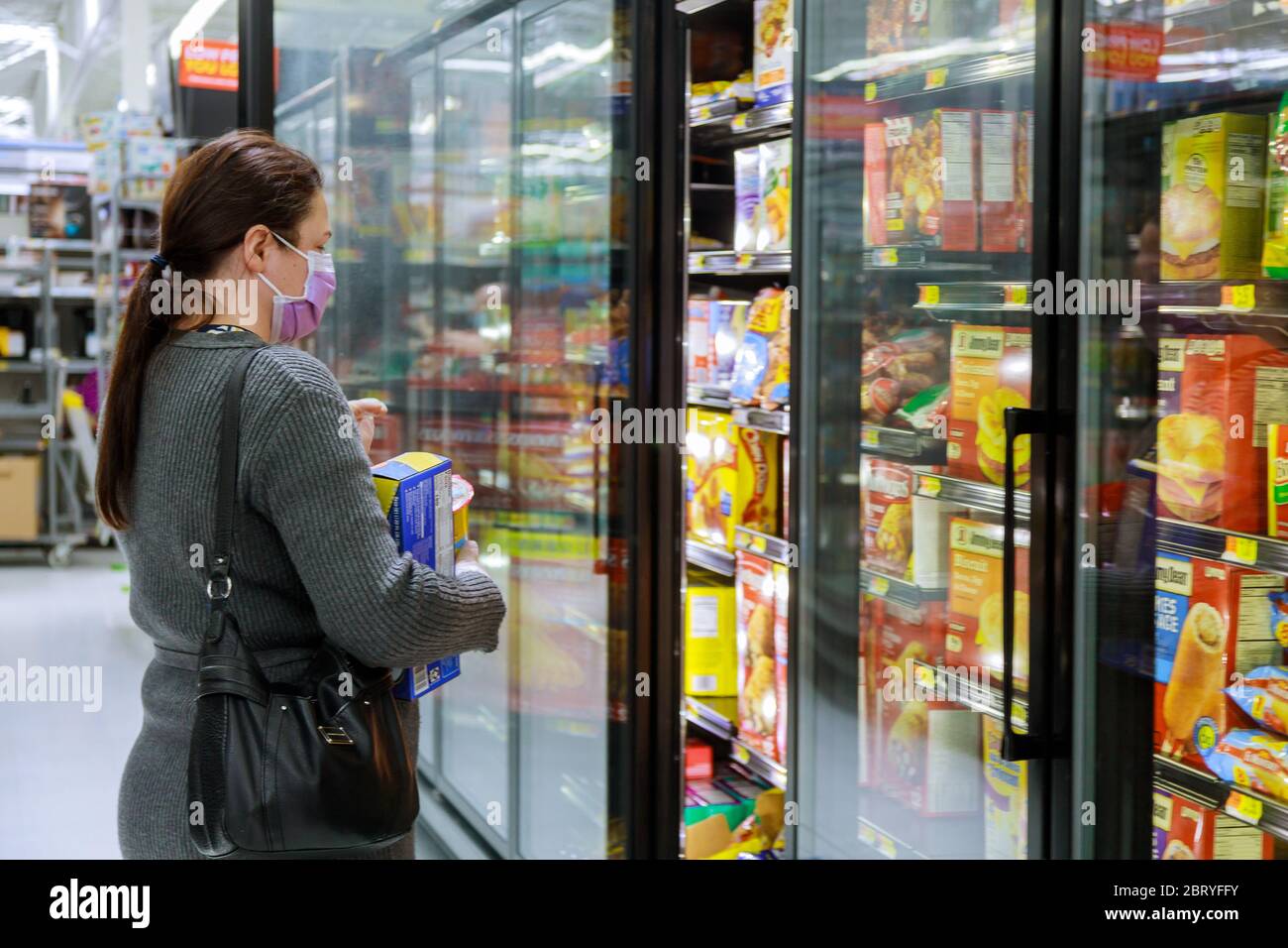 Walmart supermercato Los Angeles CA US 16 MAY 2020: Donna in maschera sta facendo acquisti in un negozio di alimentari con durante la pandemia di Coronavirus Covid-19 Foto Stock