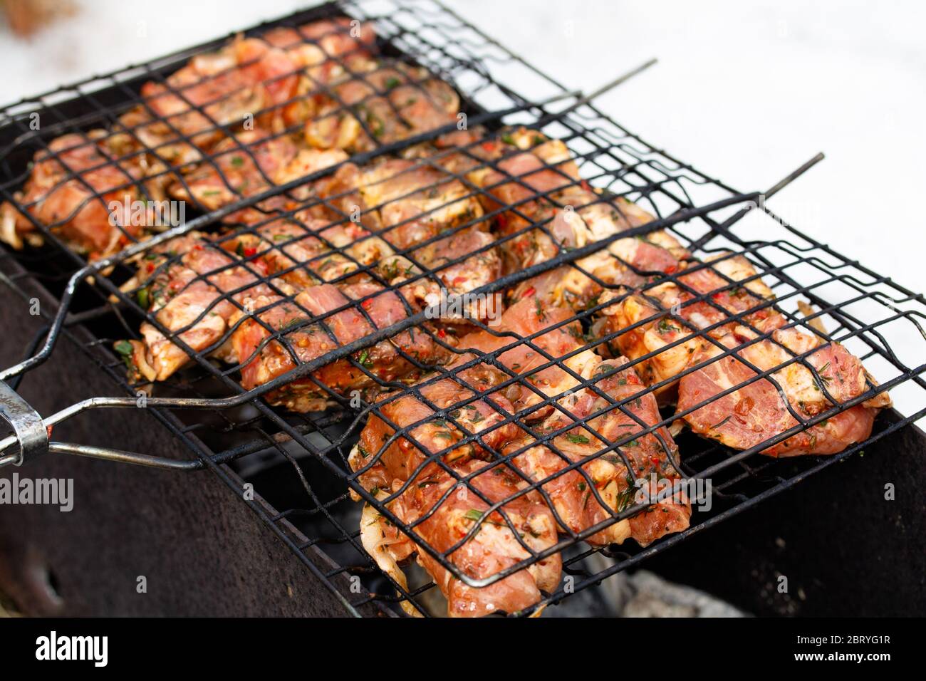 Carne di maiale cruda e succosa marinata in grate alla griglia. Cibo fresco preparato per barbecue. Cucina estiva all'aperto Foto Stock