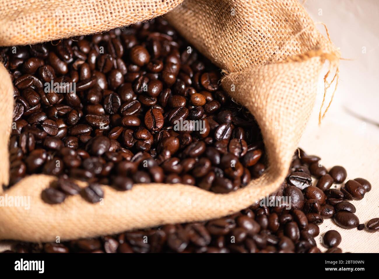 I chicchi di caffè tostati marroni in sacco a scacchi. Foto Stock