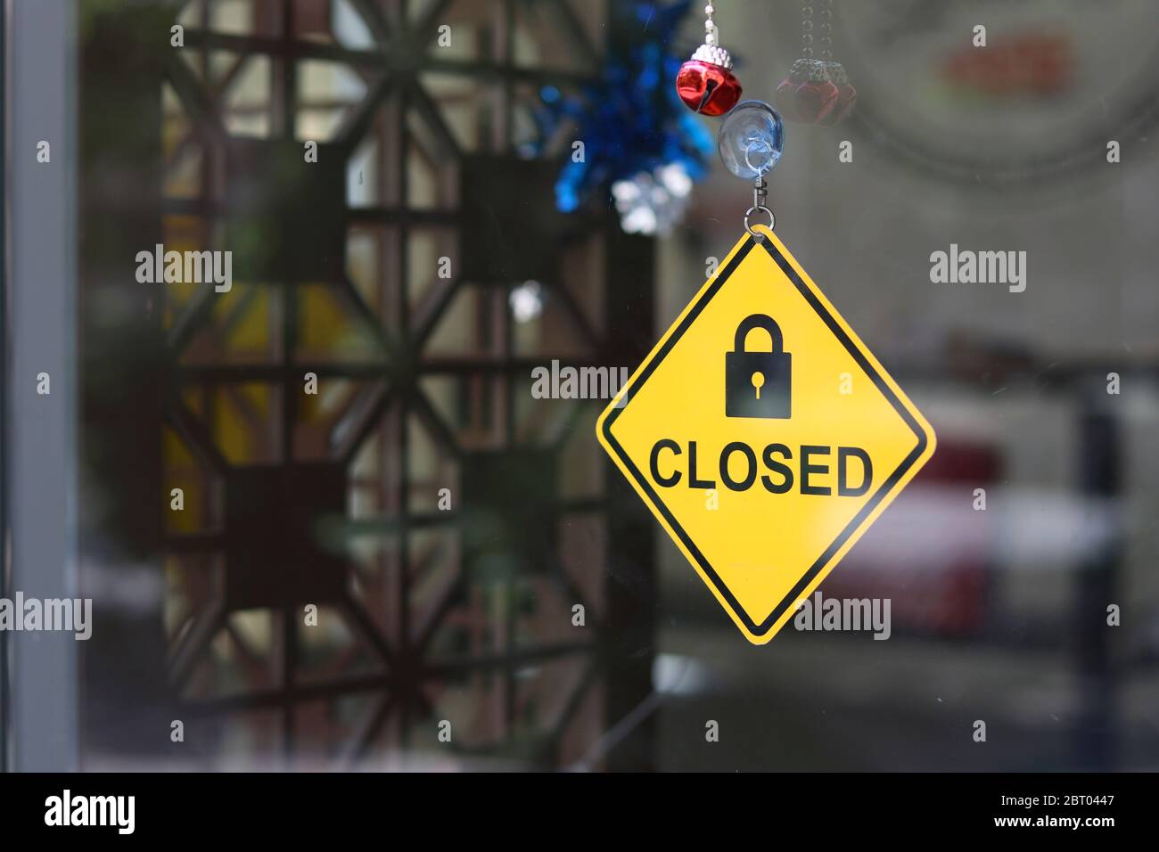Un cartello giallo che indica che il negozio è chiuso nella parte anteriore della porta del negozio. Foto Stock